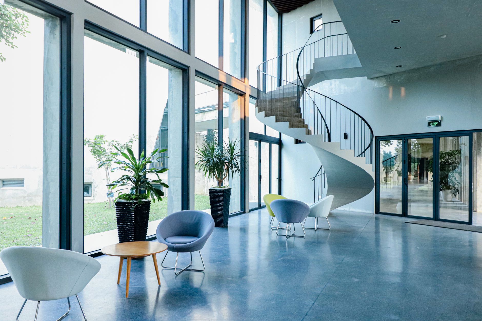 Clean, modern office building lobby with a staircase and seating area